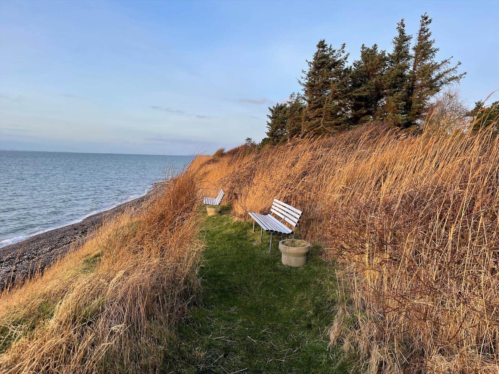 Schwarzes Holzhaus mit Garten und Blick aufs Meer