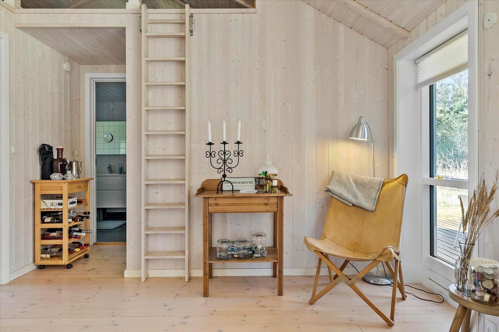 Ein Haus mit Holzterrasse und Garten. Es gibt eine Terrasse mit Tisch und Stühlen.