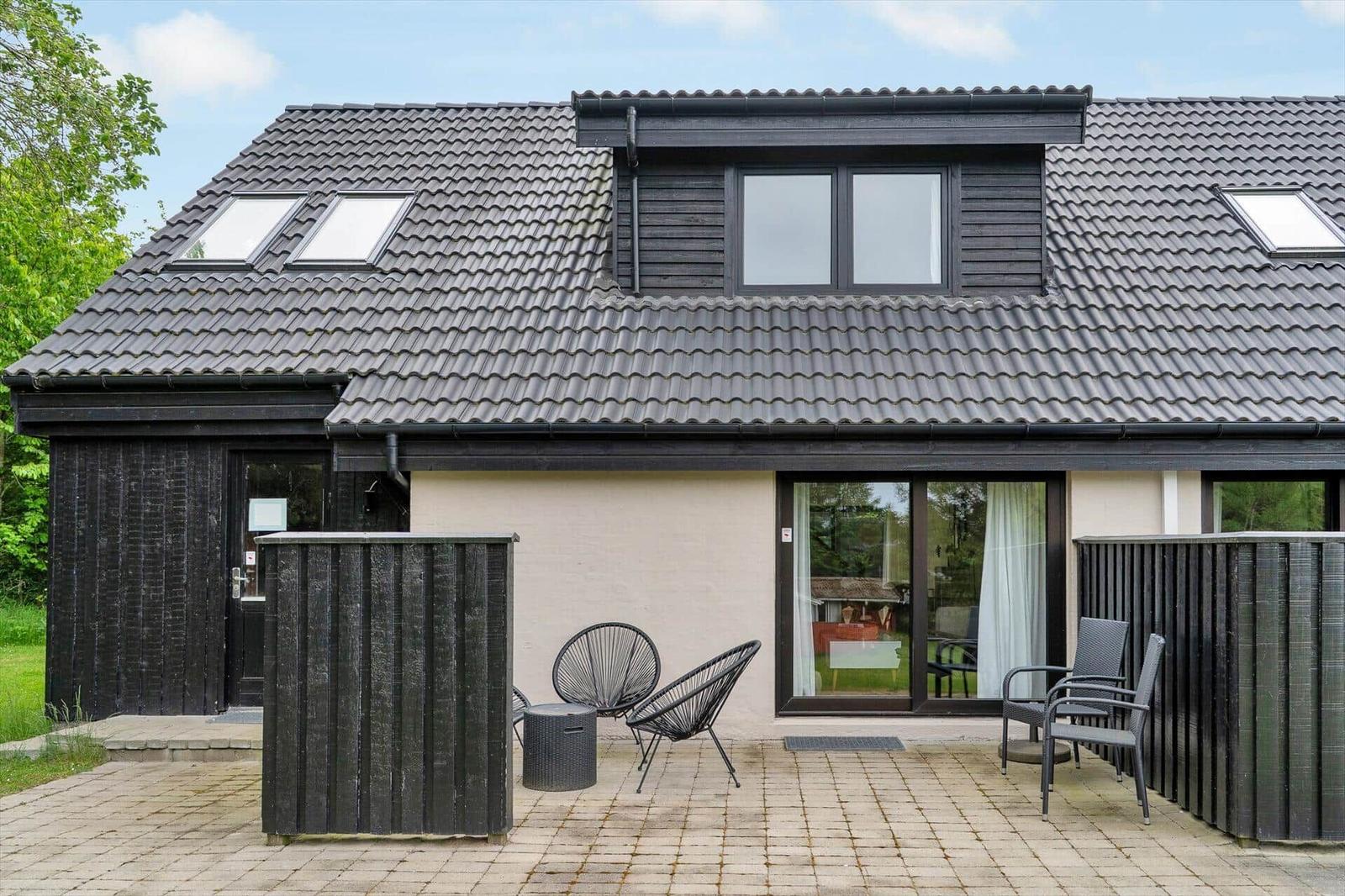 Erdgeschossplan mit Schlafzimmer, Wohnbereich und Terrasse. Mit Maßangaben und Kompass.