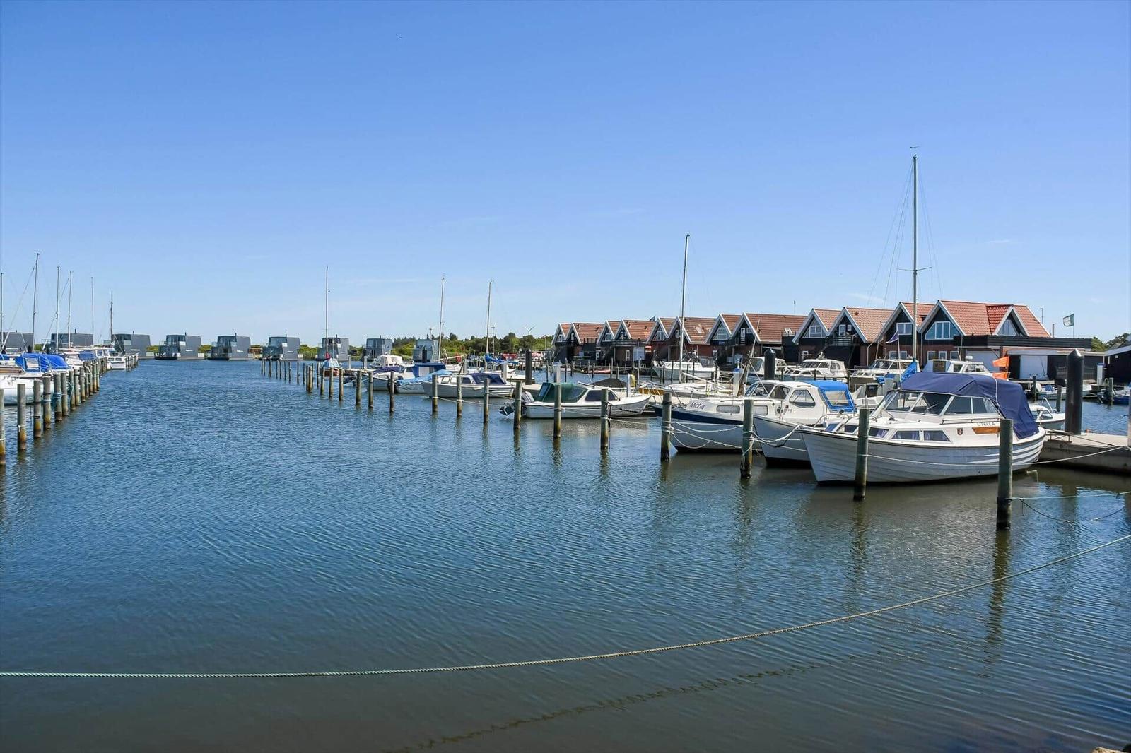 Hafen mit Booten und roten Häusern an der Wasserkante.