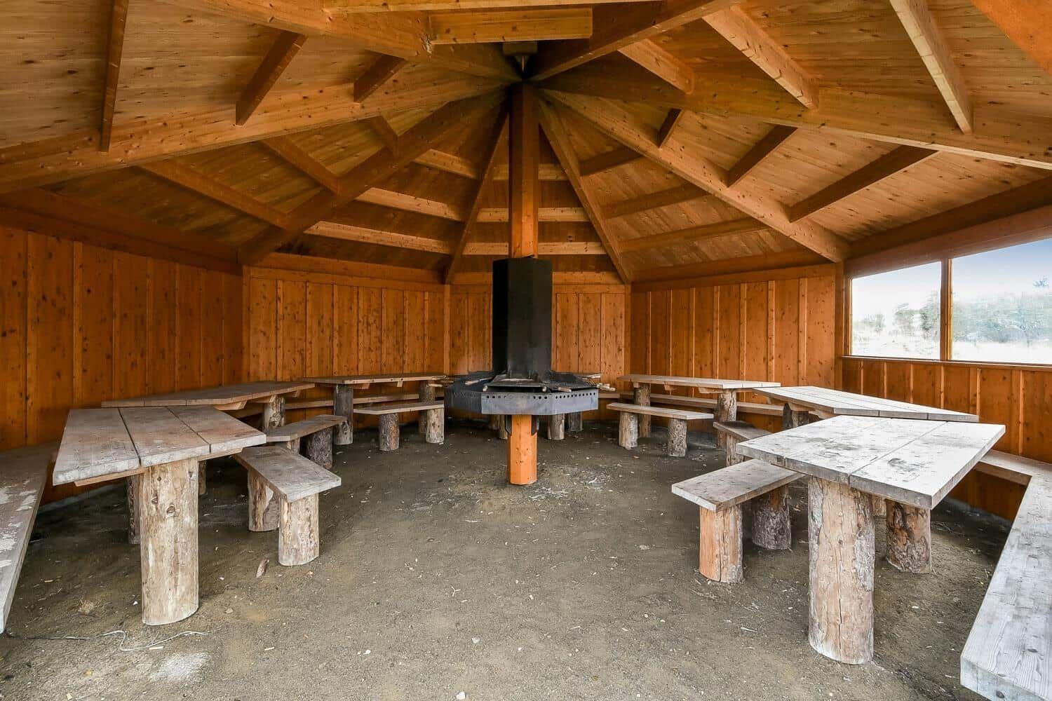 Spielplatz mit Sandkasten, Schaukel und Holzgerüst im Freien.