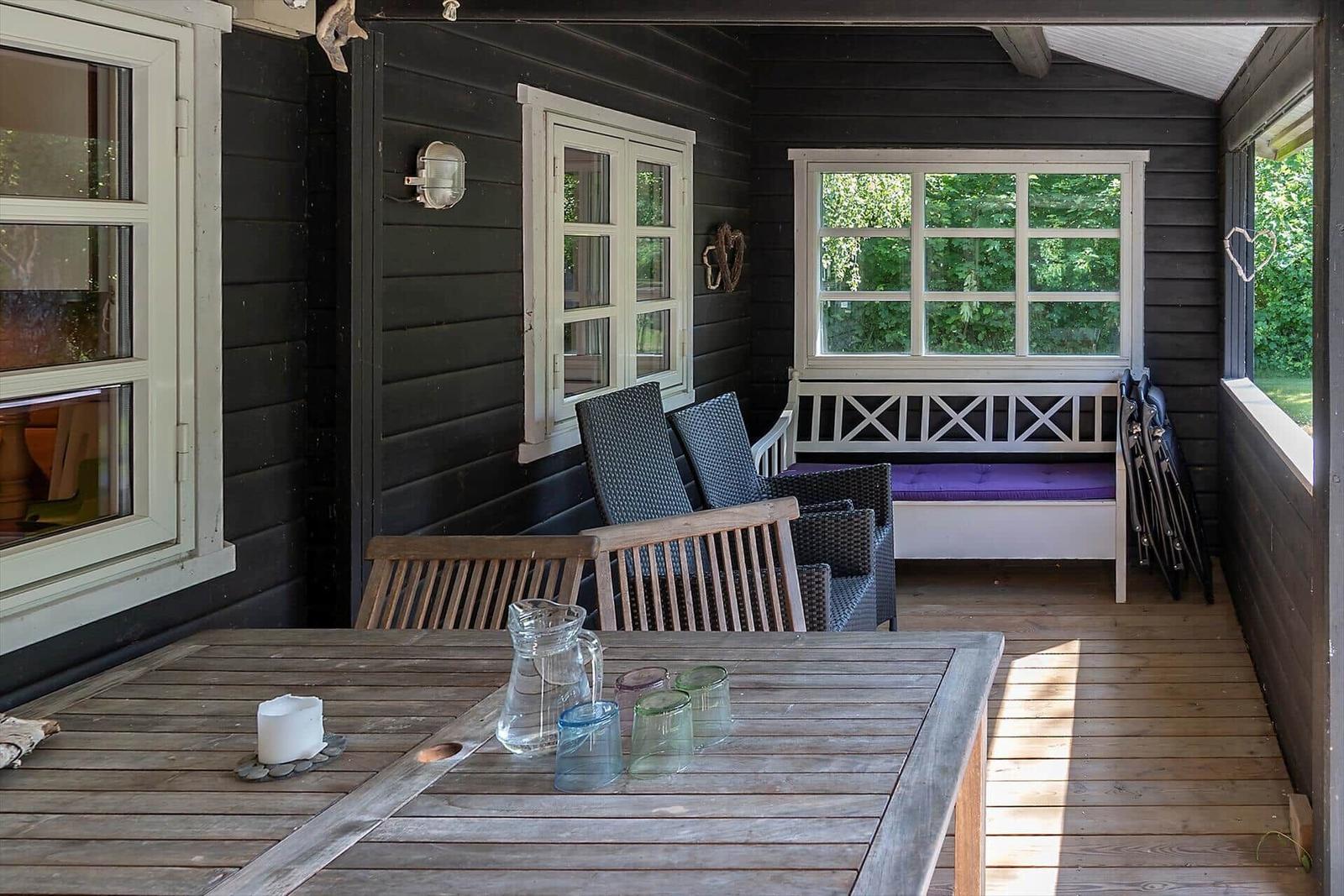 Haus an Strand mit grünen Hügeln und Meeresblick
