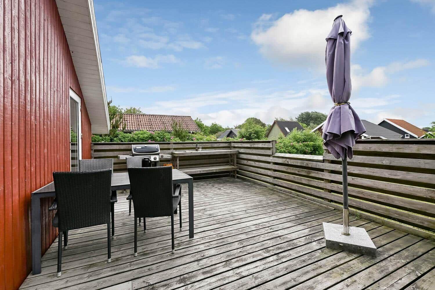 Weber Grill auf Terrasse mit Pflanzen und Gartenmöbeln