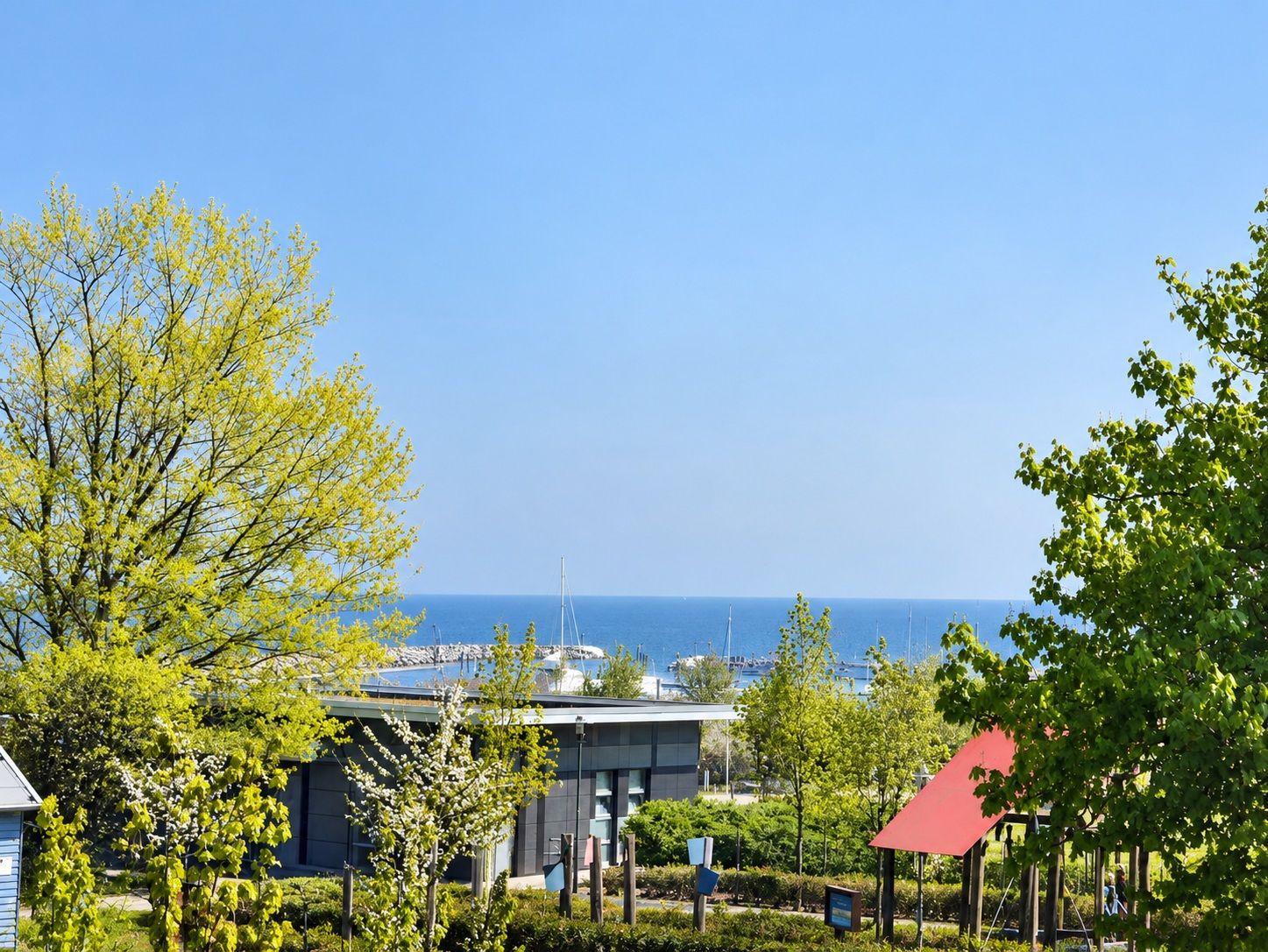 Blick auf den Hafen mit Bäumen und einem roten Pavillon im Vordergrund.