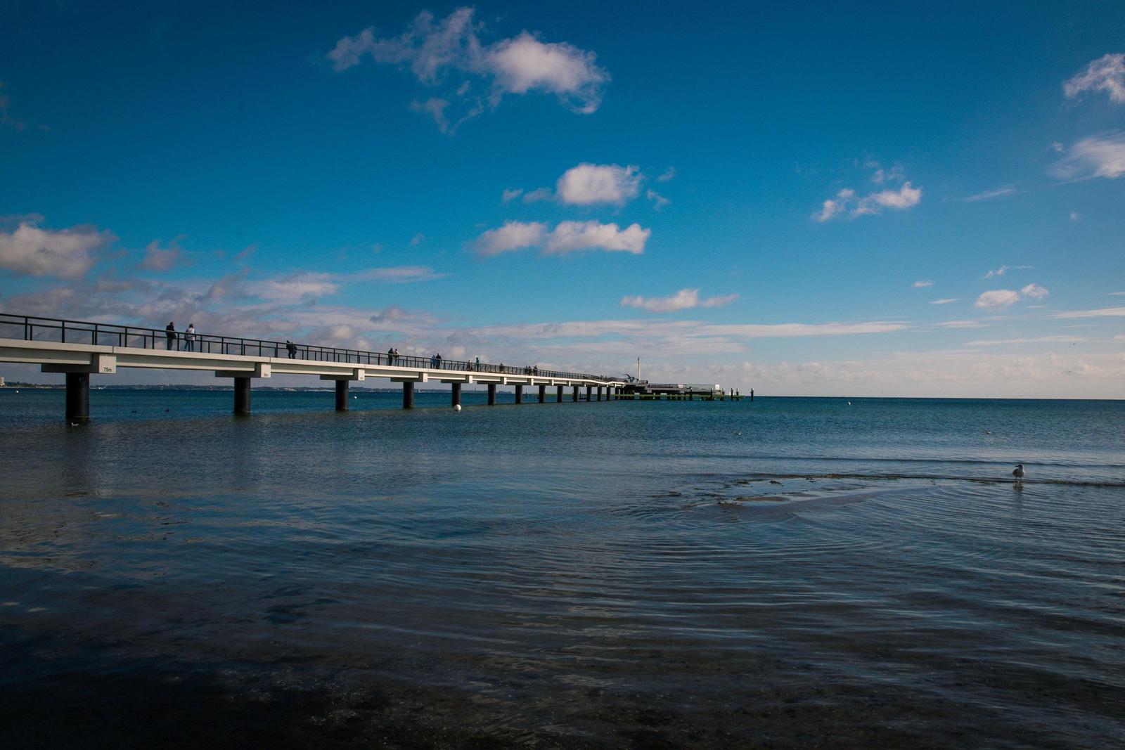 Strand mit Pier unter klarem Himmel