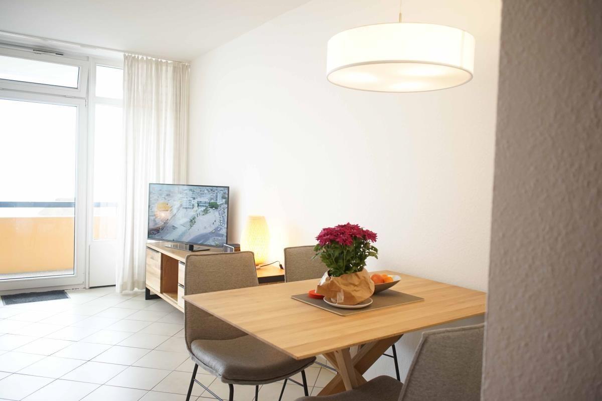 Heller Wohnbereich mit Esstisch und Fernseher