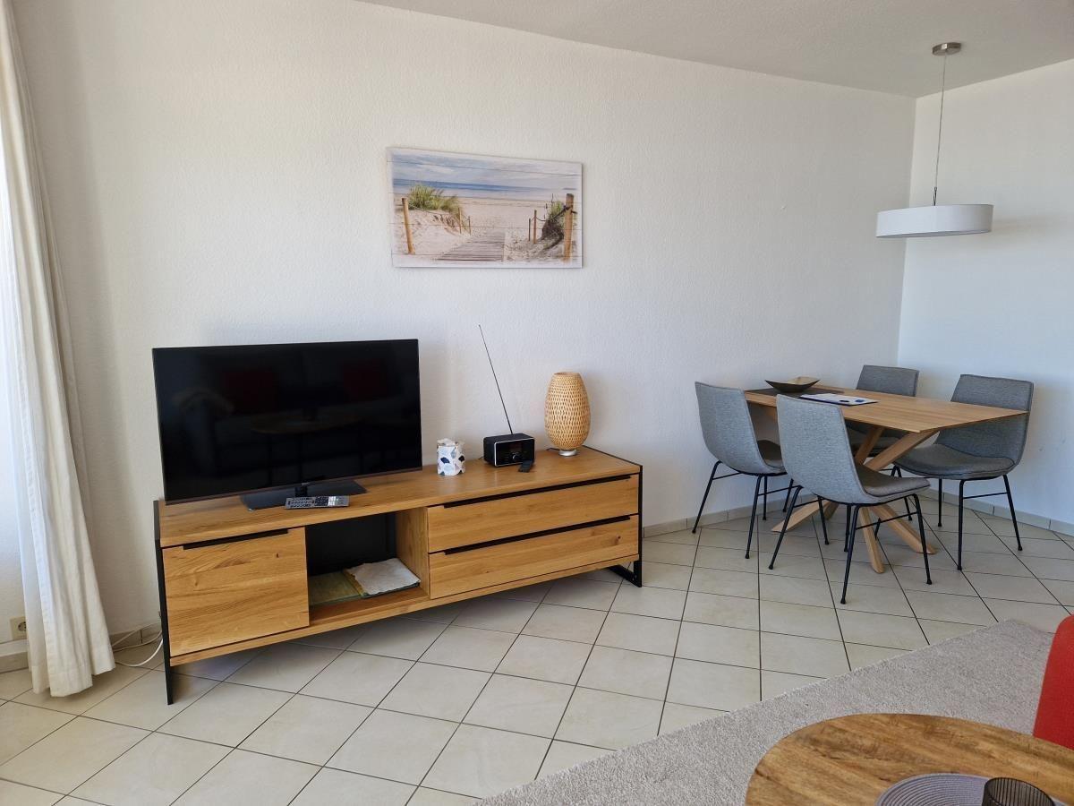 Gemütliches Wohnzimmer mit Fernseher und Esstisch
