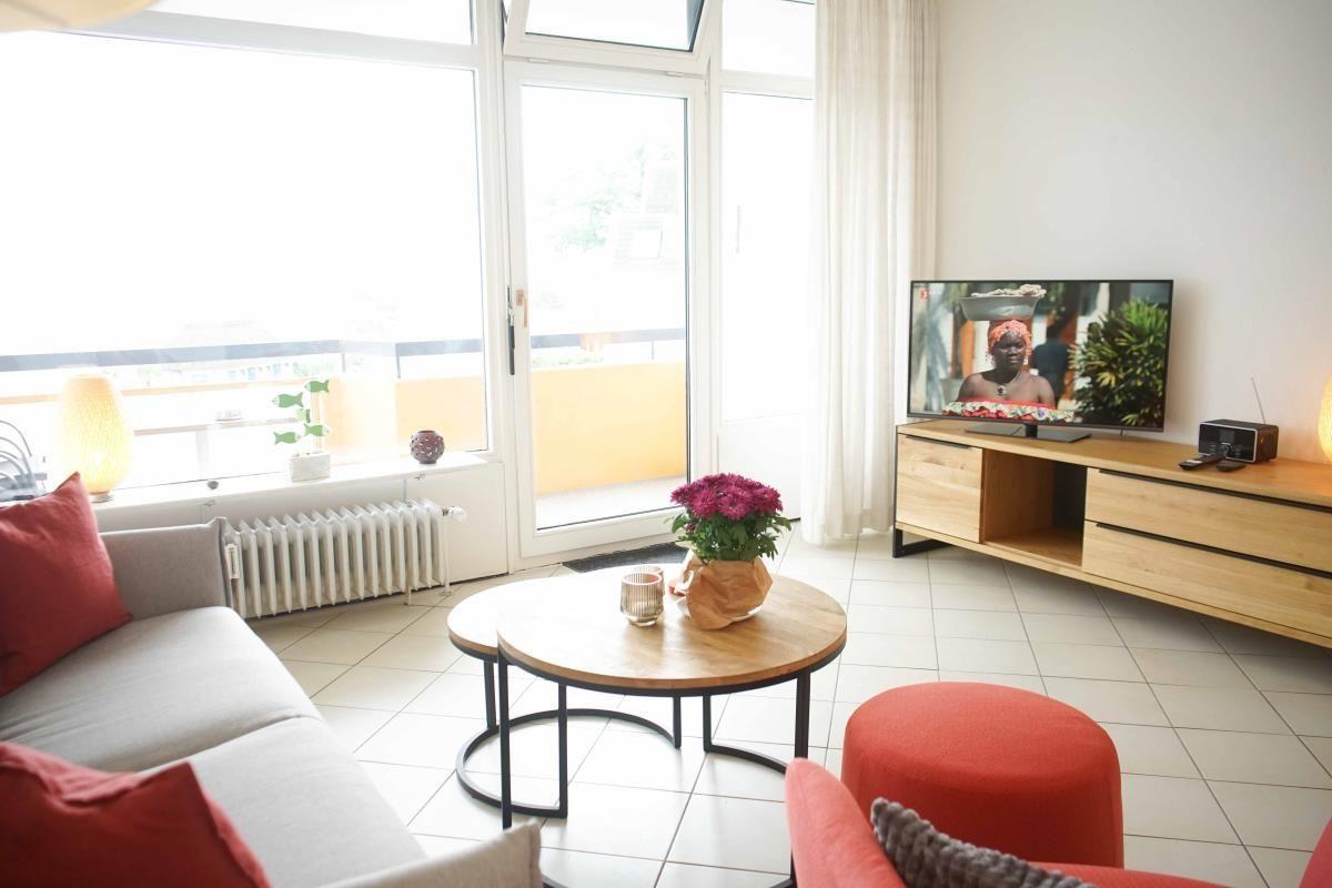 Helles Wohnzimmer mit Sofa und Fernseher