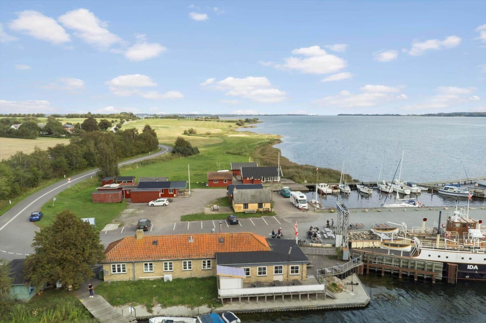 A house with terrace, garden, and view of trees.