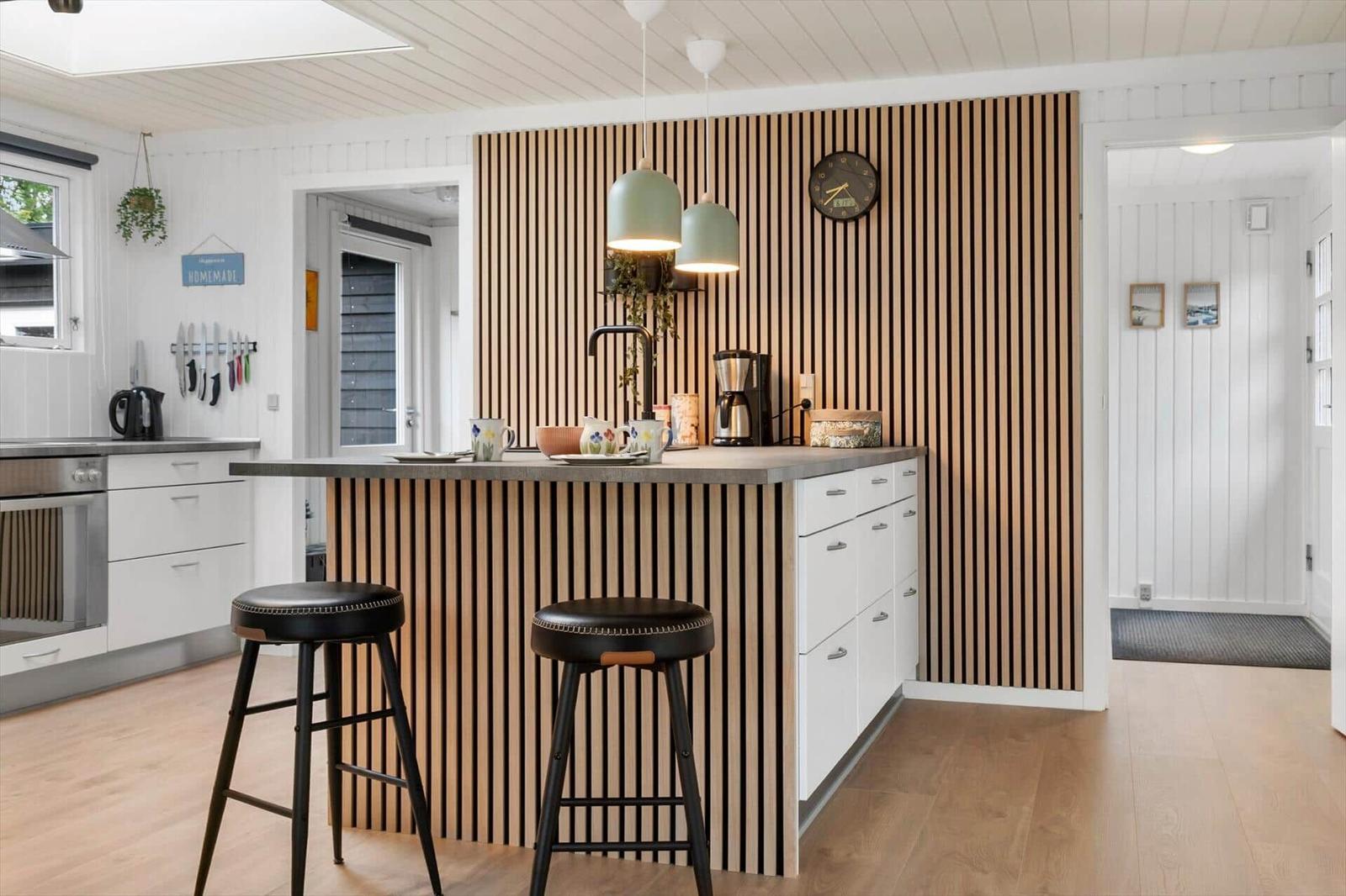 Küche mit Holzwand, Arbeitsplatz und Barhocker