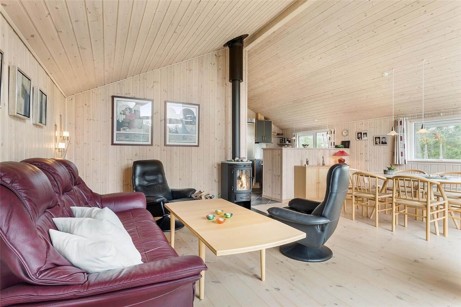 Wohnzimmer mit Sofa, Sessel und Kamin. Essbereich mit Tisch und Stühlen.