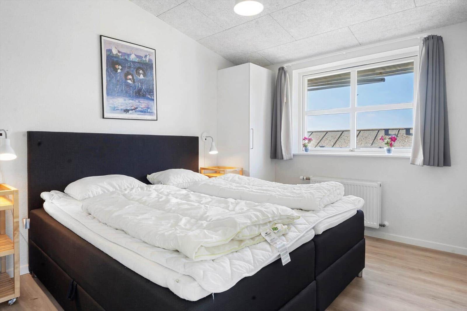 Wohnung mit Küche, Bad, zwei Schlafzimmern und Aufzug. Raumgrößen sind eingezeichnet.