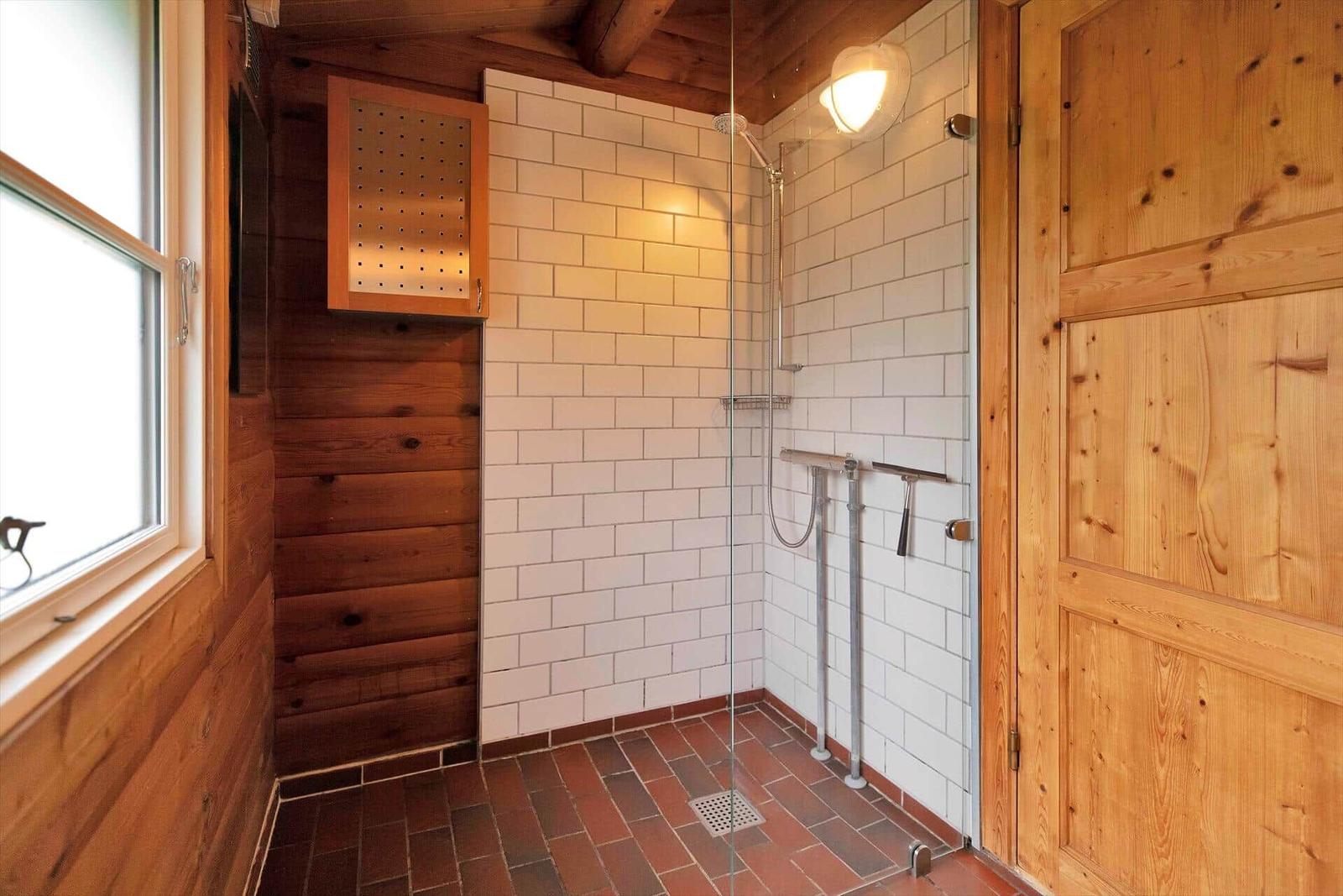 Schwarzes Holzhaus mit Dach und Fenstern auf grünem Rasen