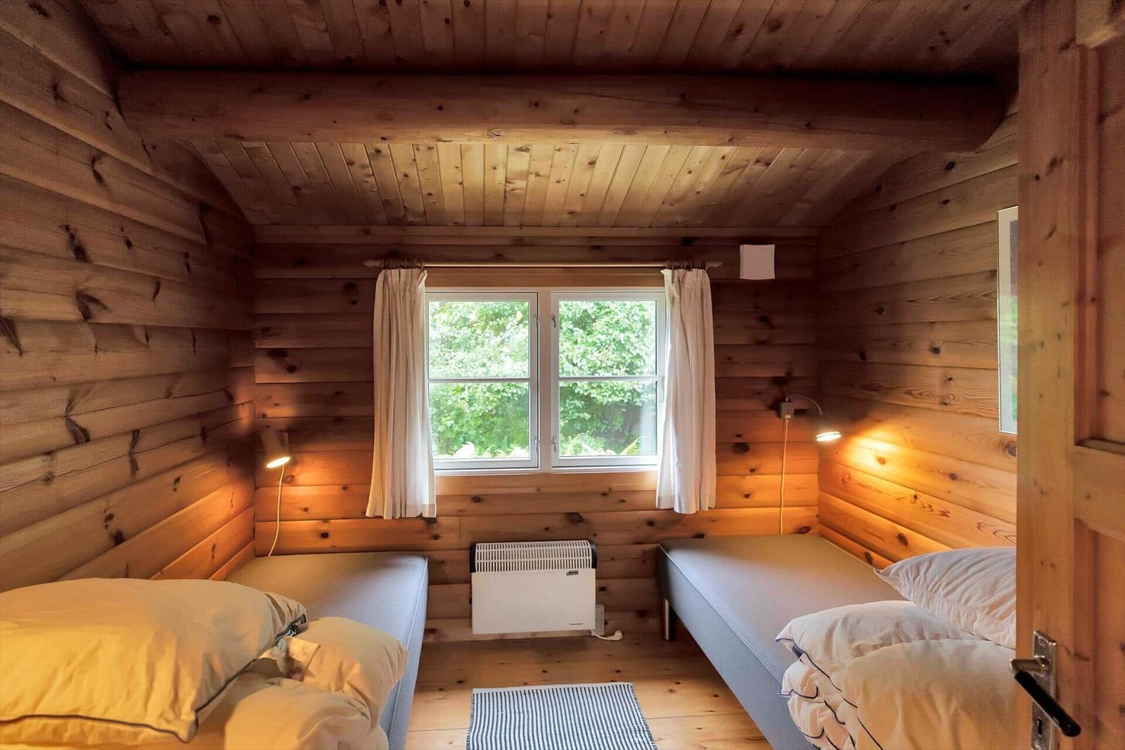 Ein Teich mit einer kleinen Hütte, umgeben von Bäumen und Gebäuden.