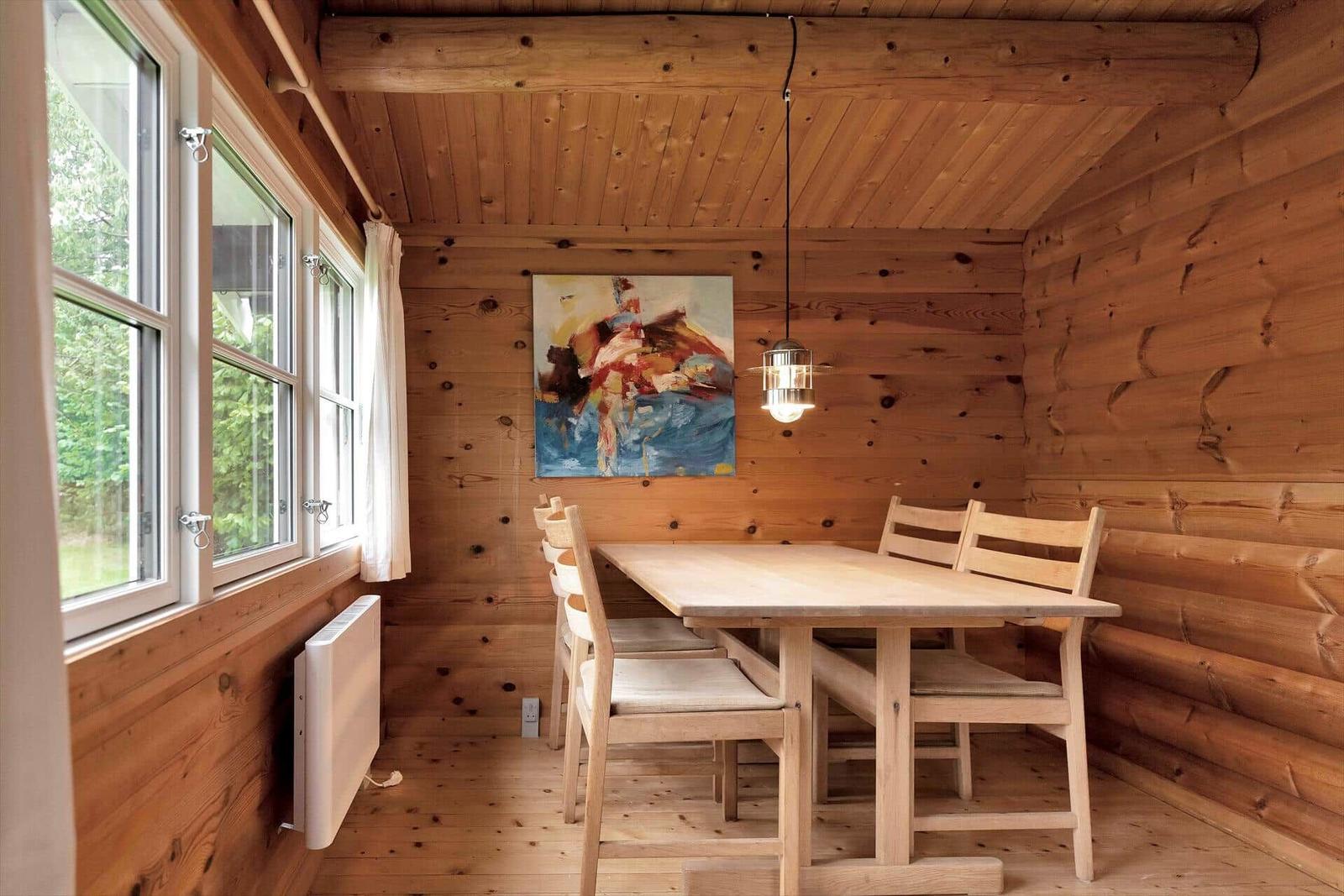 Wohnzimmer mit Holzwand, Sofa, Tisch, Teppich und Fernseher.