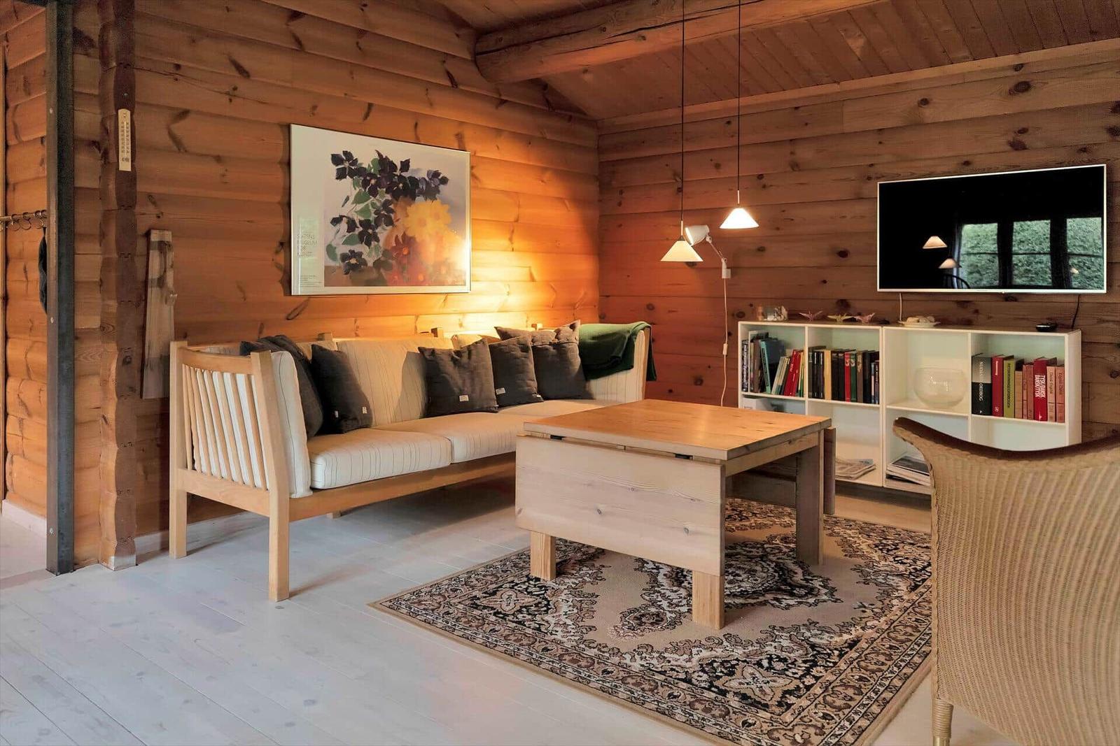 Zwei Betten in einem holzverkleideten Raum mit Fenster und Heizung.