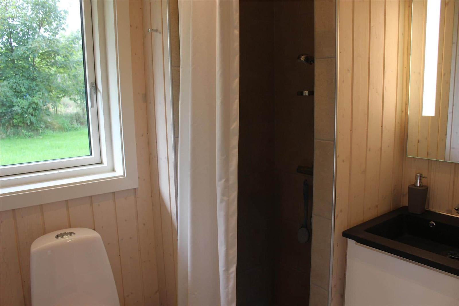 Küche mit türkisfarbenen Schränken und Insel. Hintergrund: Schlafbereich mit Doppelstockbett.