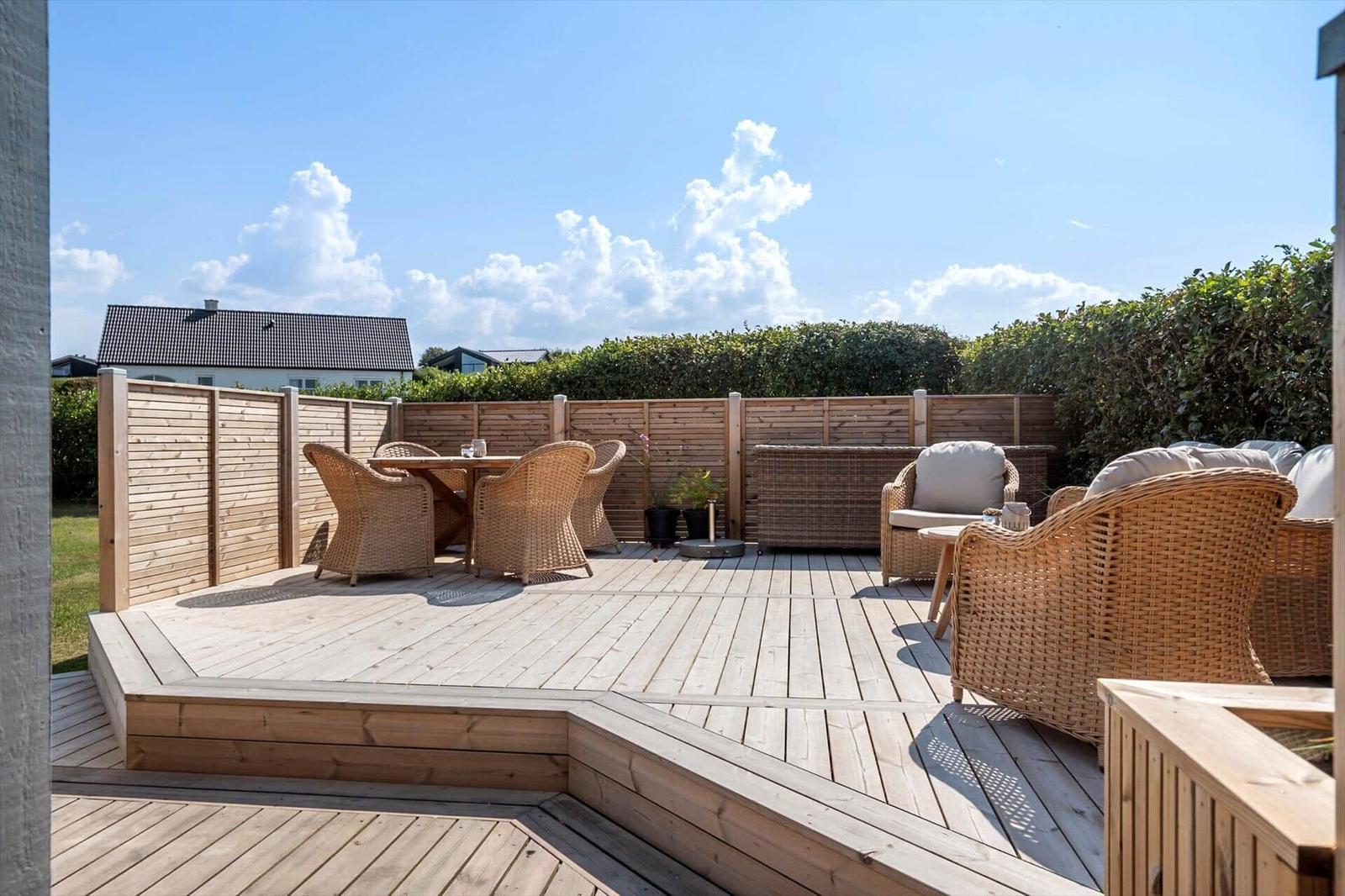 Terrasse mit Picknicktisch, Garten und Blick aufs Meer.