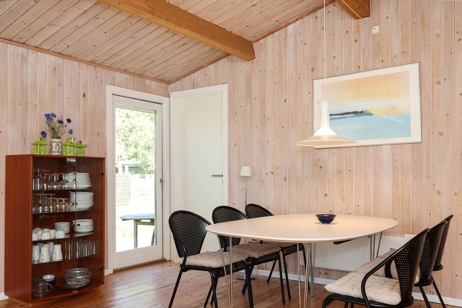 Two beds in a wood-paneled room with windows and wall lamps.