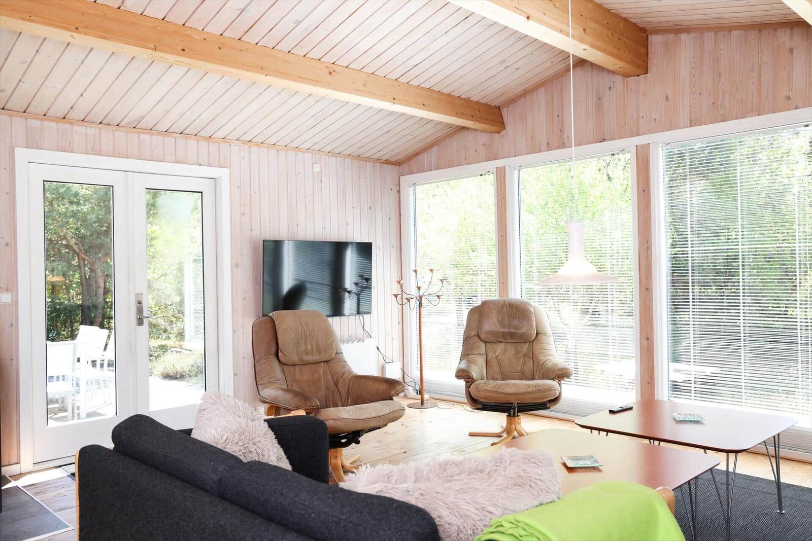 Bedroom with wooden walls, bed, and window with blinds.