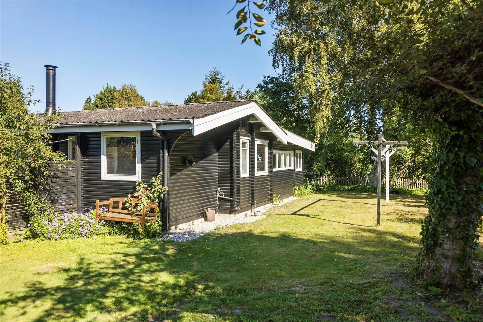 Cabin with open door, wooden wall, and anchor decoration.