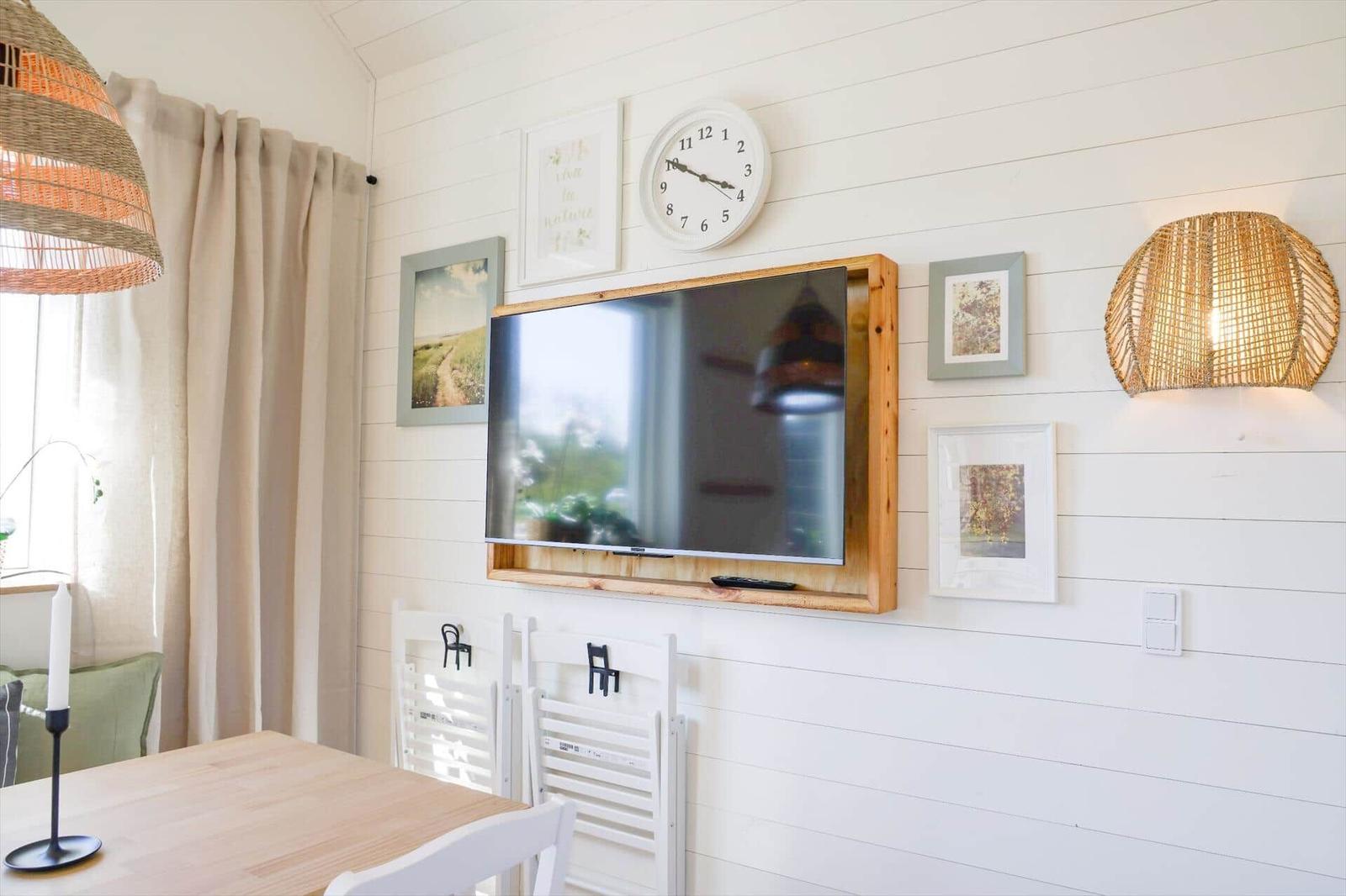 Room with two beds, wooden shelf, plant, and skylight.