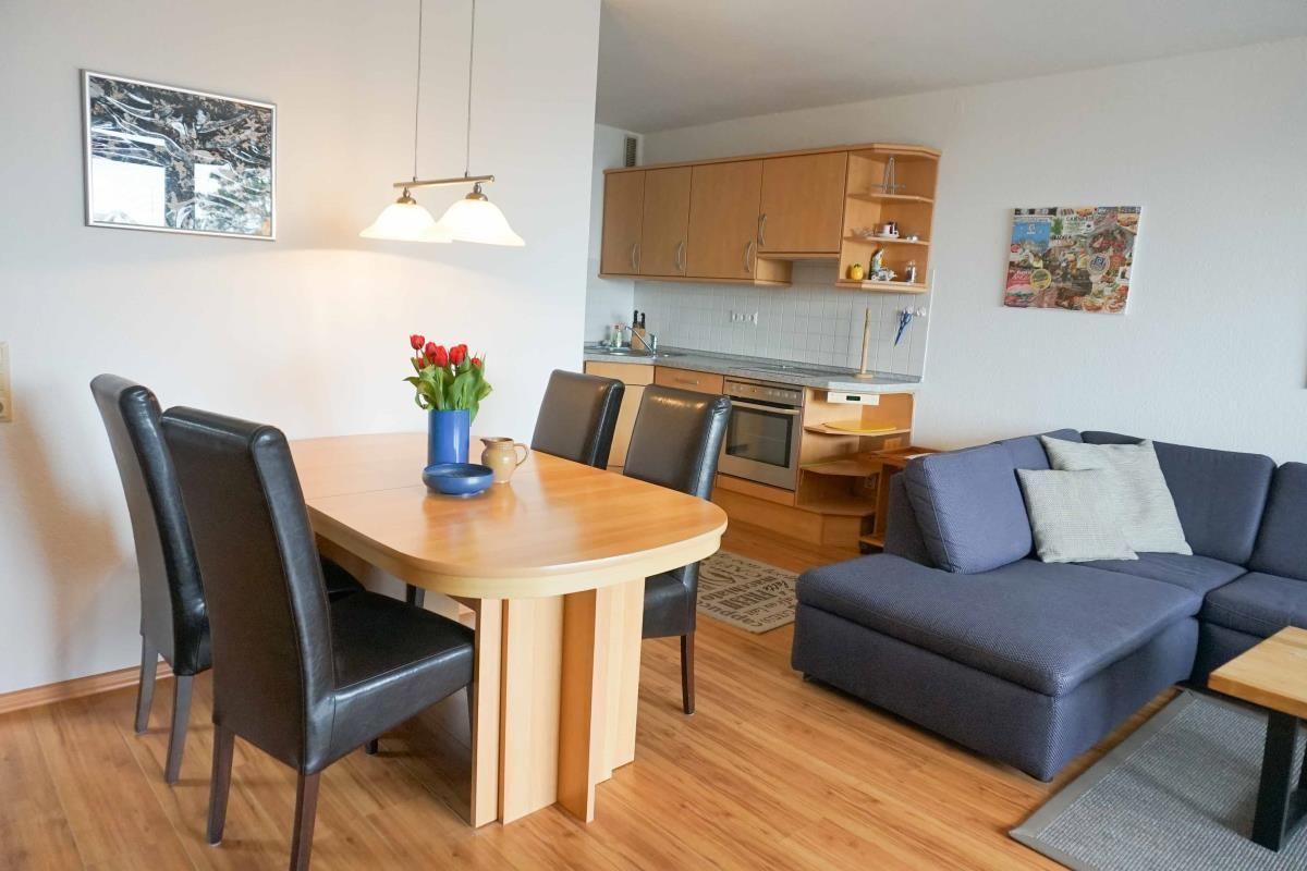 Wohnzimmer mit Esstisch und offener Küche