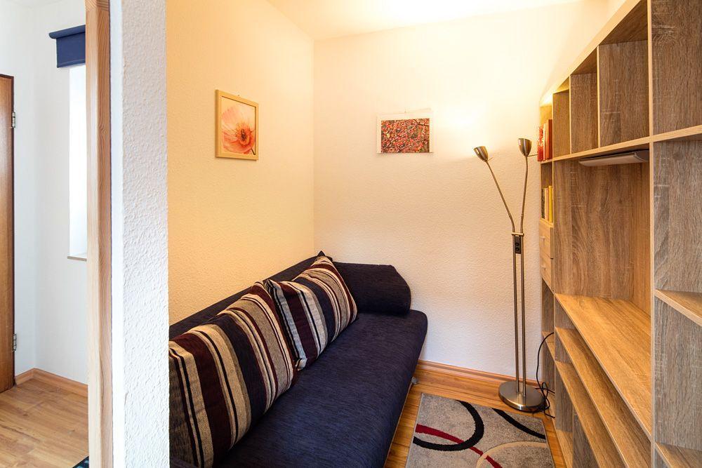Kleines Wohnzimmer mit Sofa und Bücherregal