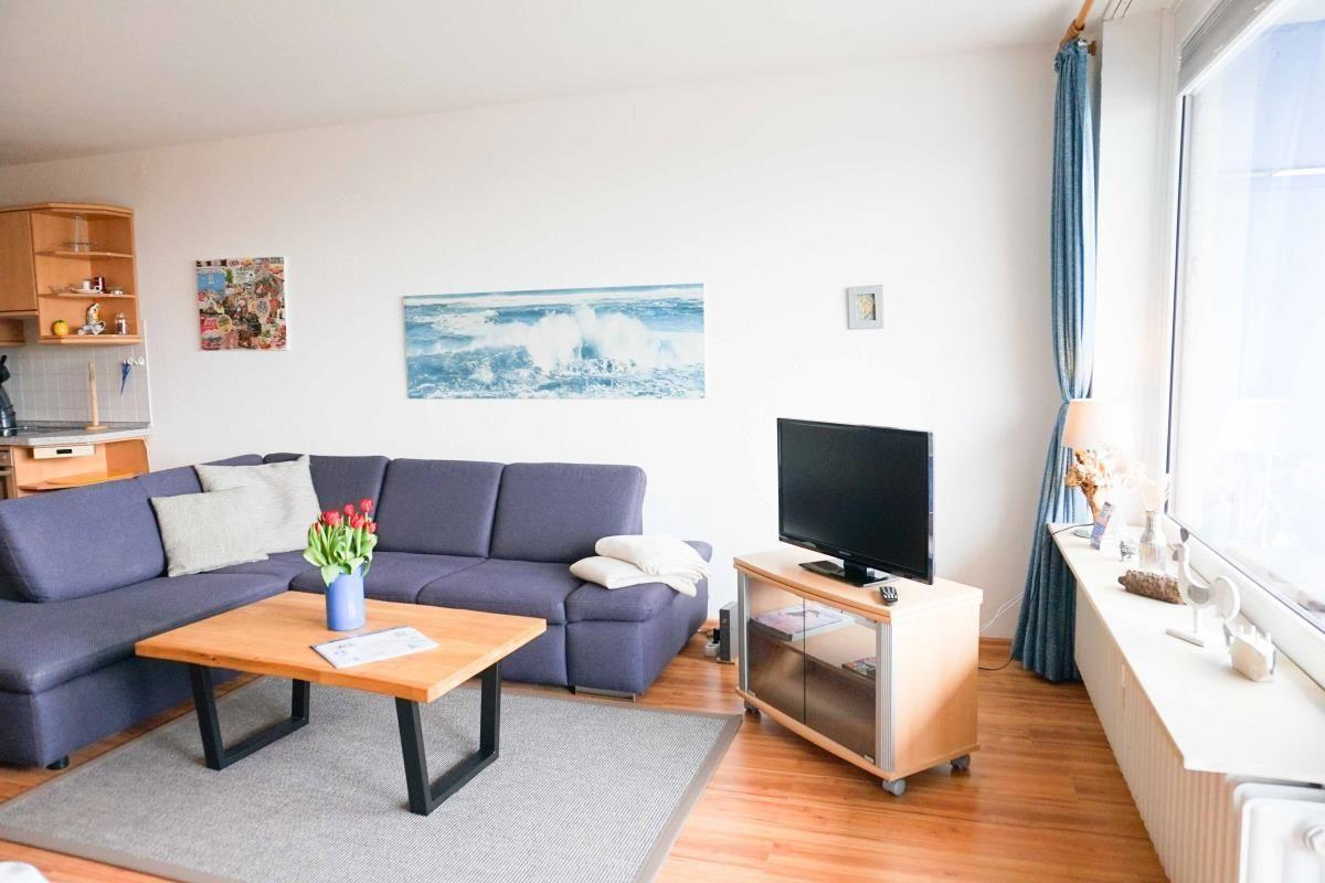 Gemütliches Wohnzimmer mit Sofa und Fernseher