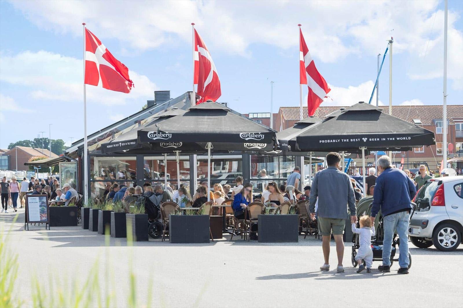 Strand mit Badegästen, Segelyachten und Rettungsschwimmerstation