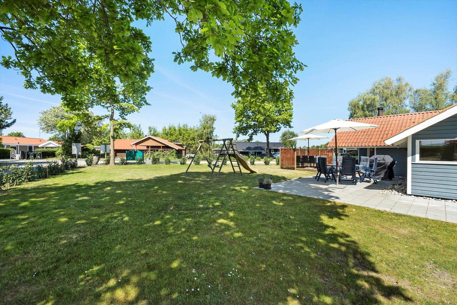 Strandbad mit Holzumrandung und rotem Willkommensschild. Menschen baden und sonnen.