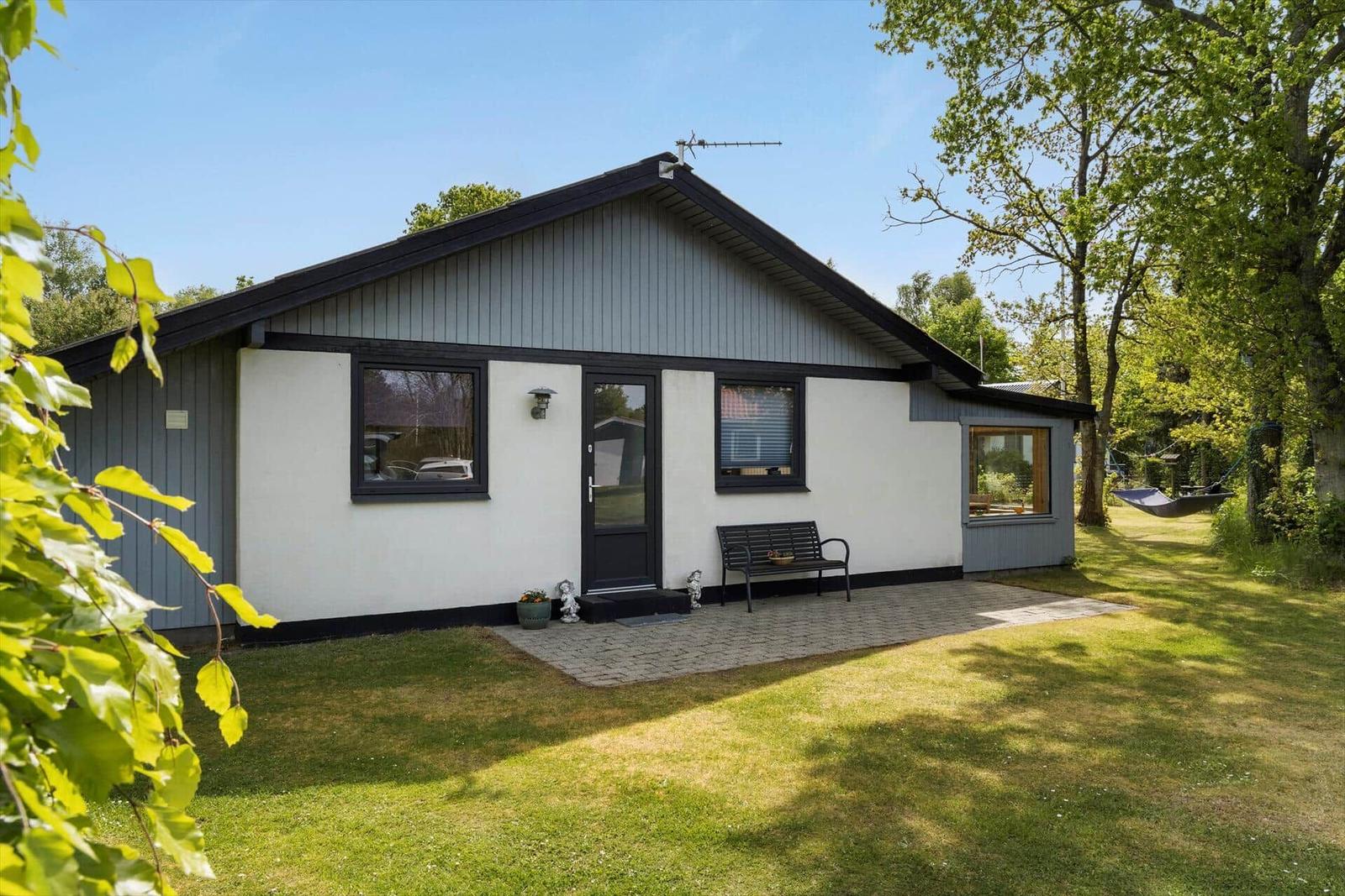 Flur mit Tür zum Bad und zur Wohnung, Holzboden und weiße Wände.