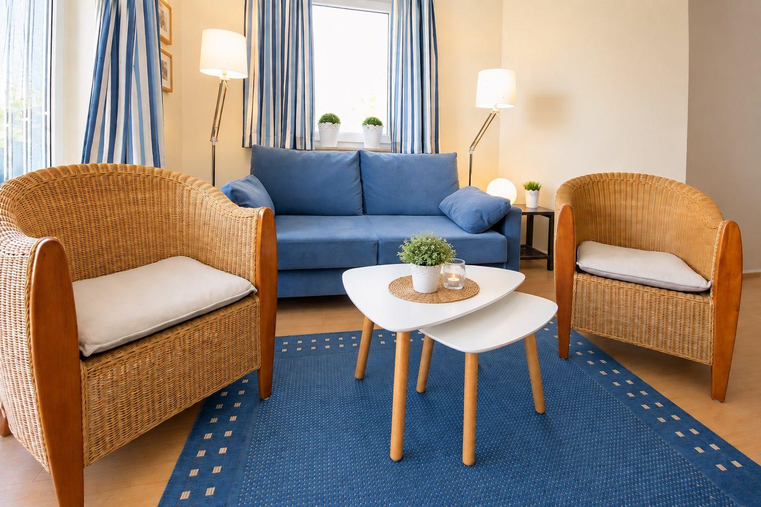 Living room with blue sofa, two rattan chairs, and wooden table on blue rug.