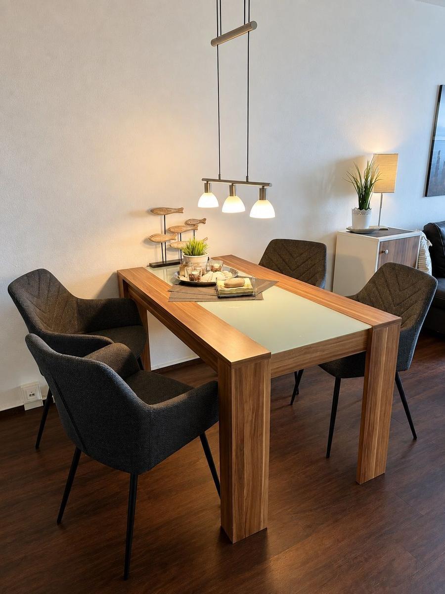 Schlafzimmer mit Doppelbett, Kleiderschrank und Fenster mit Vorhängen.