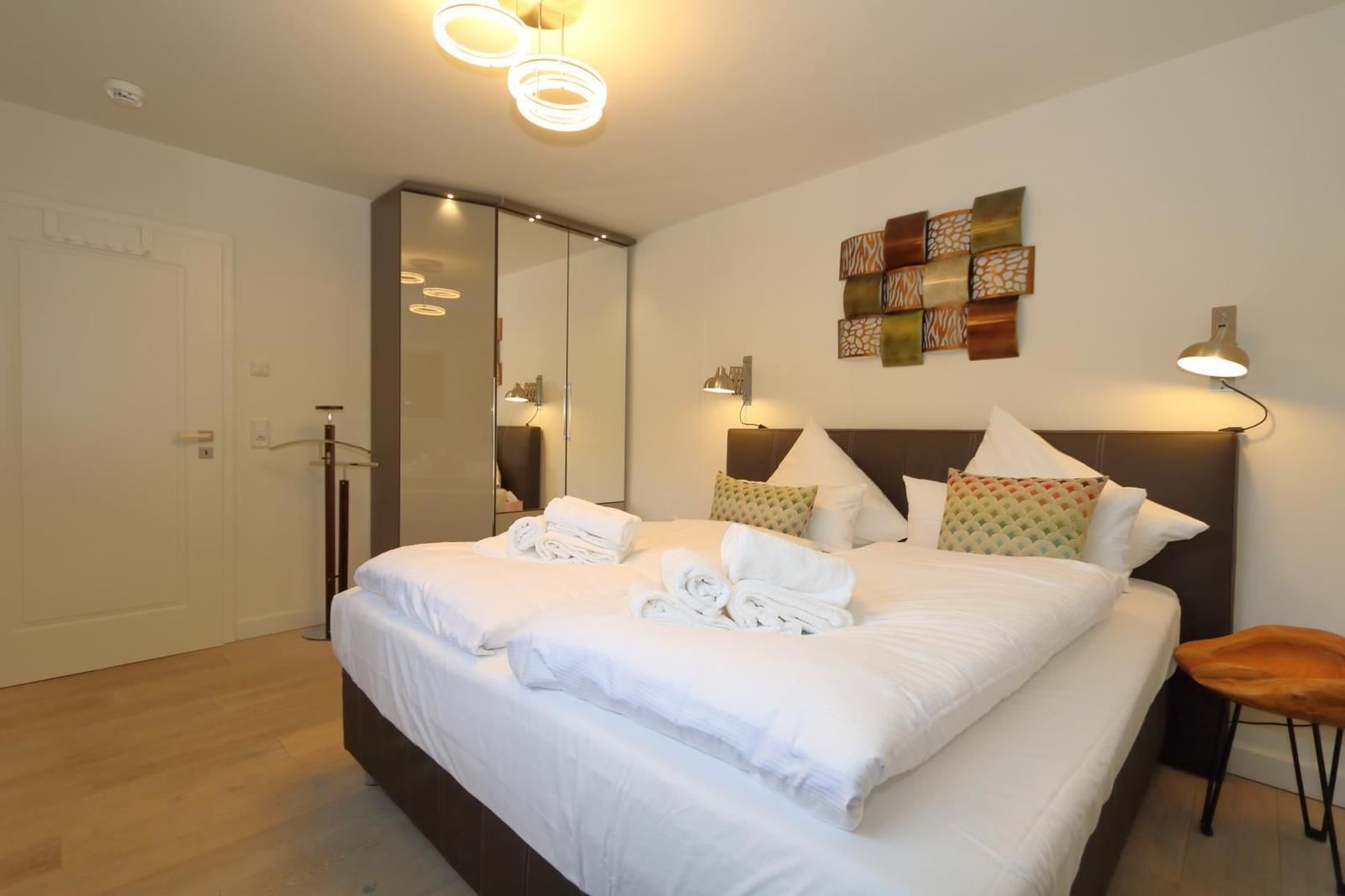 Rundes Esszimmer mit Holztisch, braunen Stühlen und Wandbildern.