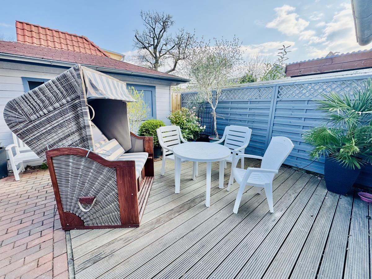 Haus mit rotem Dach am Wasser, Boote vor Anlegestelle