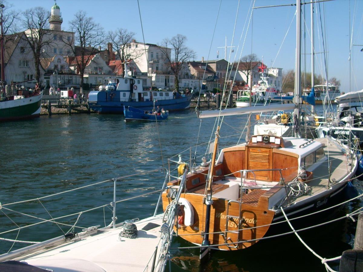 Hafen bei Dämmerung mit Booten und beleuchteten Gebäuden am Ufer.