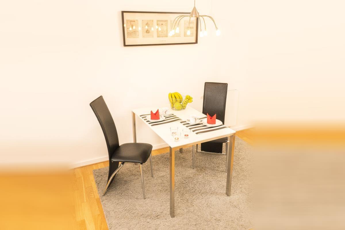 Flur mit Holzboden, Schrank und Einkaufstasche mit Früchten.