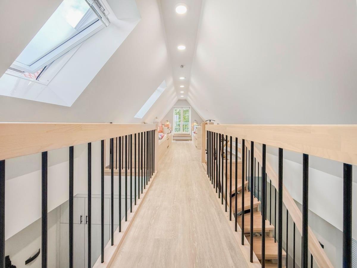 Flur mit weißen Türen, Holzboden und Schrank mit Dekorationsgegenständen.