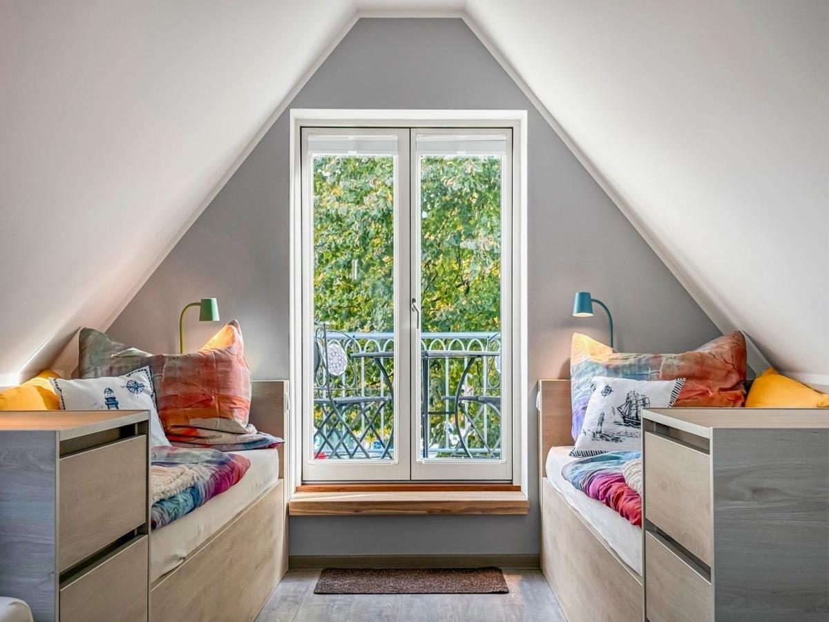 Eingangsbereich mit Holzboden, Tür, Fenster und Wanddekoration.