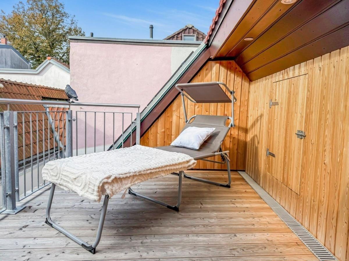 Gewölbter Raum mit Holzwand, grauen Schränken und Fenster mit Vorhängen.