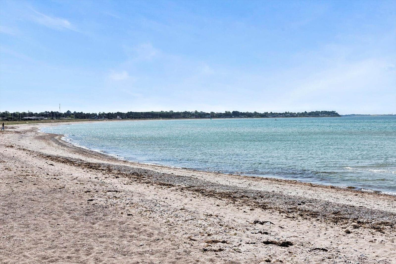 A couple walks along a path to the beach and the sea.