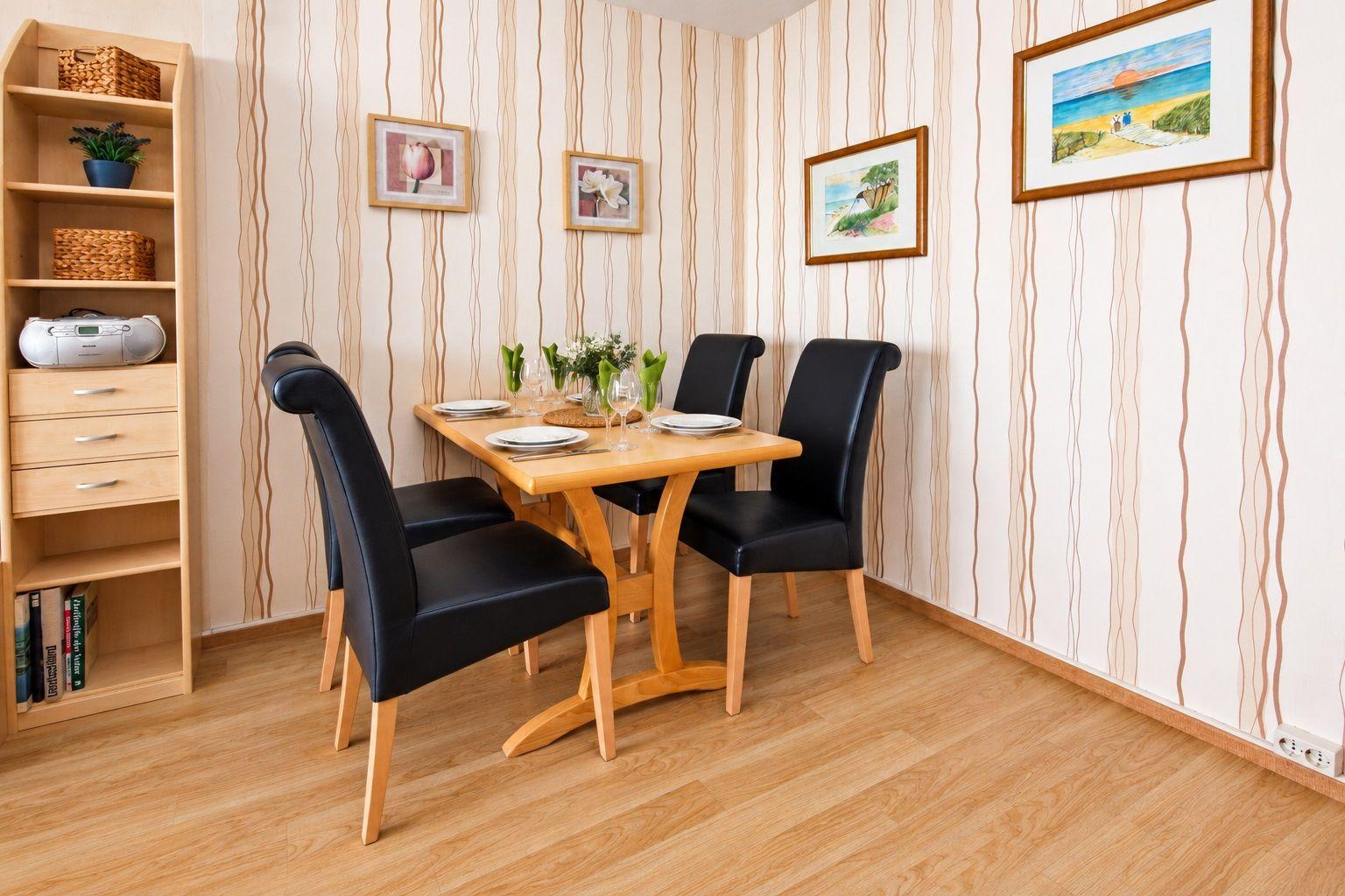 Ein Wohnzimmer mit Sofa, zwei Sesseln und einem Tisch mit Fernbedienung.