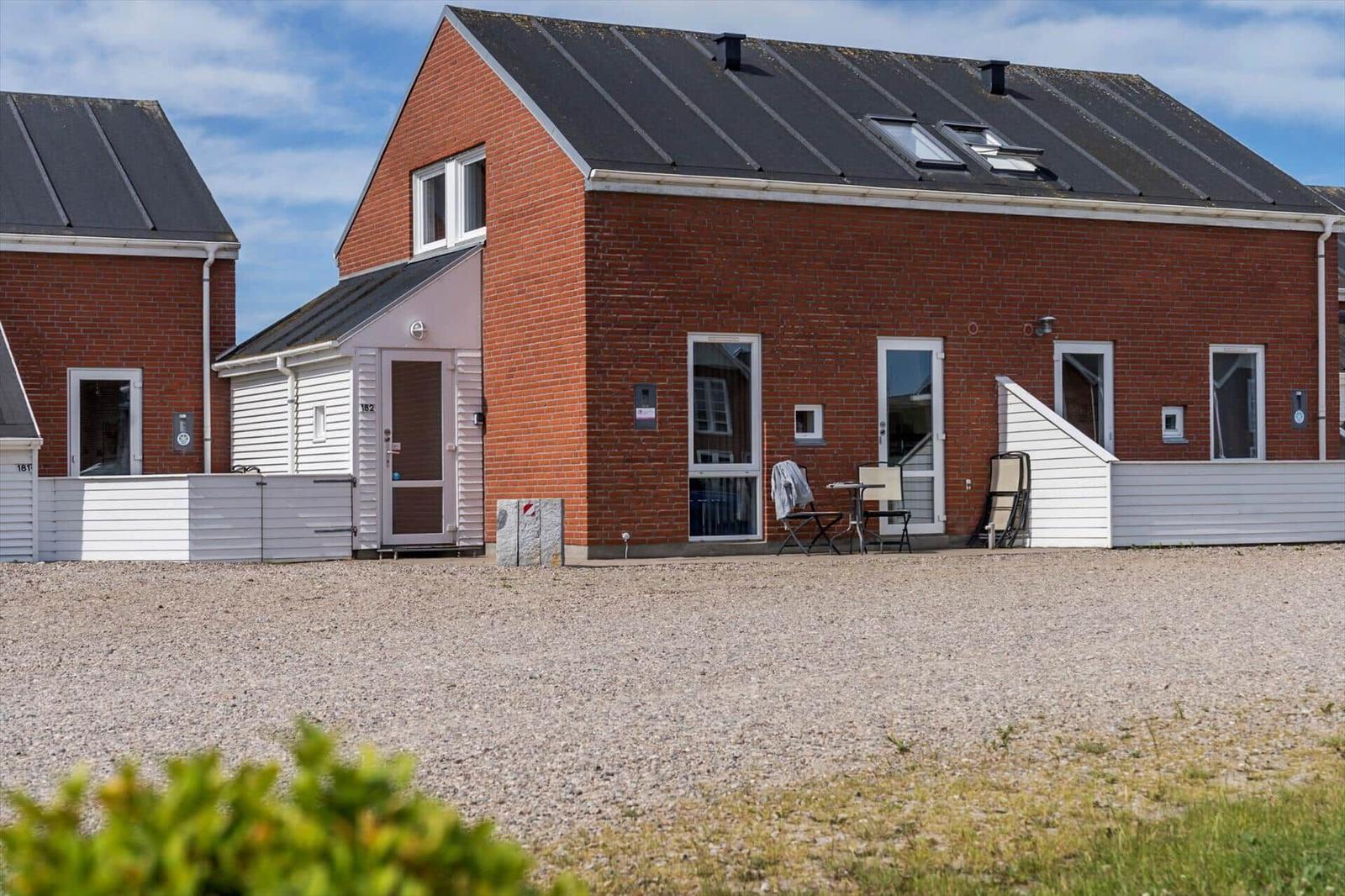 Terrasse mit Liegestuhl und Blick auf grüne Wiesen und Bäume.