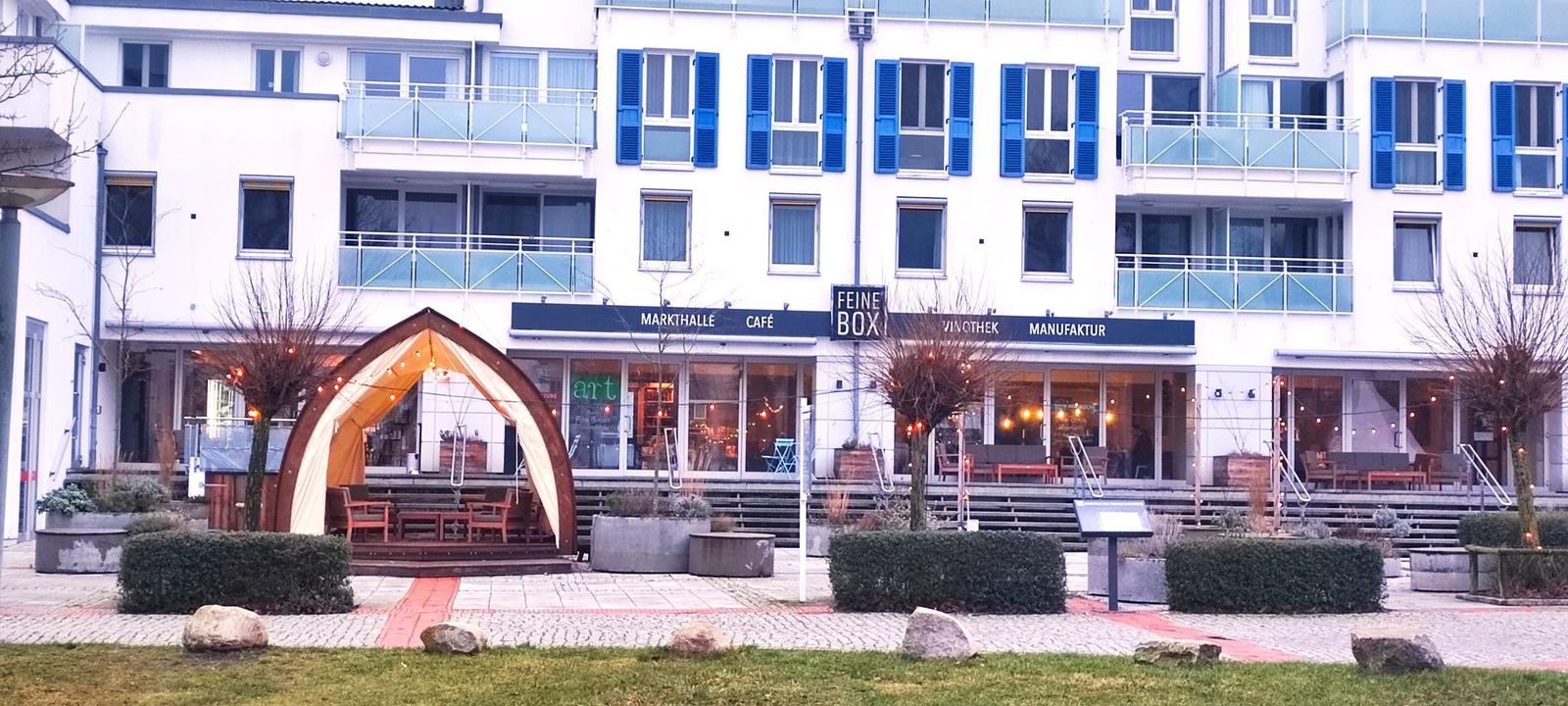 Moderne weiße Wohnanlage mit Balkonen und blauen Fensterläden.