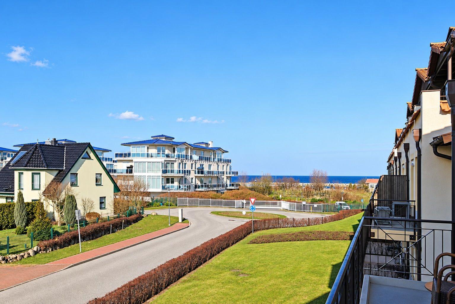 Blick auf Wohnhäuser und den Strand mit blauem Himmel.