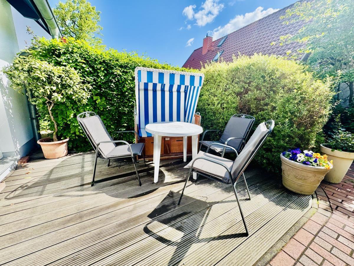 Wohnzimmer mit Sofa, Tisch, Fernseher und Blick auf Balkon.