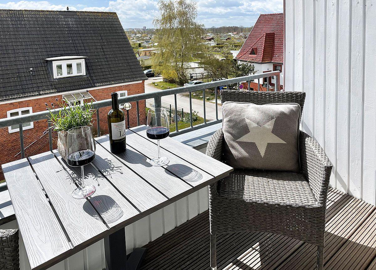 Wohn- und Essbereich mit Holzboden, Sofa, Tisch und Fensterblick.