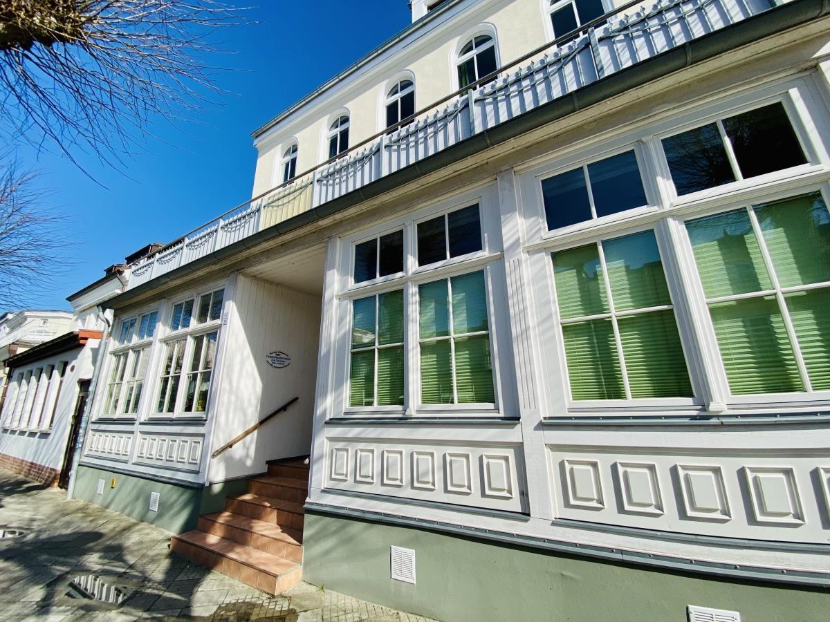 Küche mit Induktionskochfeld, Spüle und weißen Schränken unter schrägem Dach