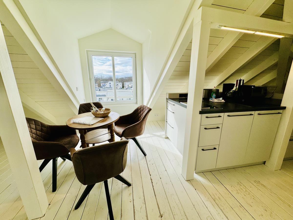 Schlafzimmer mit Doppelbett, Dachfenster und Holzregal.